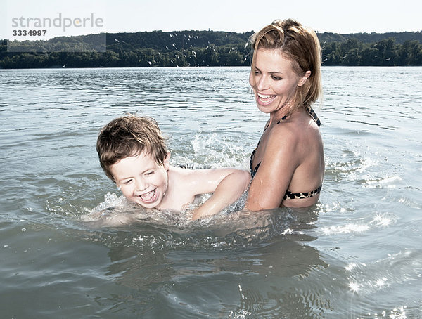 Mutter bringt dem Kind das Schwimmen bei