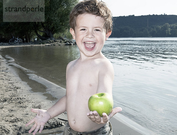 Kind hält Apfel am Fluss