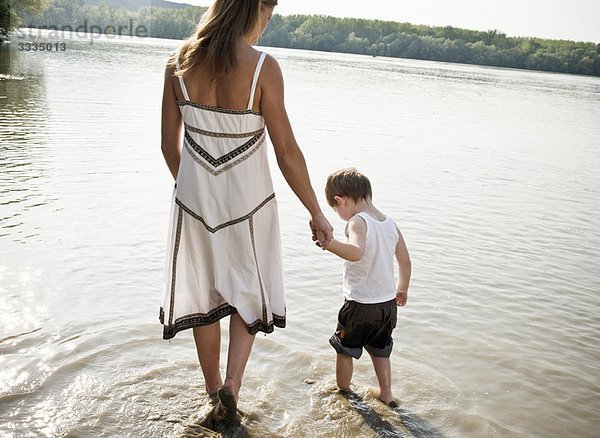 Mutter führt Kind im Fluss