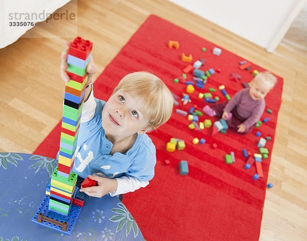 Junge und Baby mit Spielzeugbausteinen