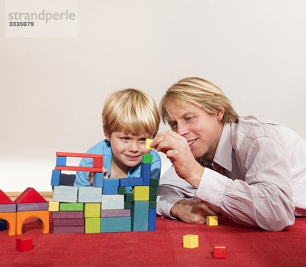 Vater und Sohn spielen mit Bausteinen