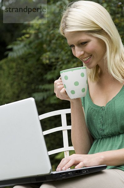 Mädchen am Computer mit Tasse