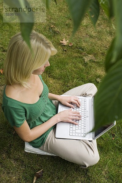 Mädchen am Computer im Garten