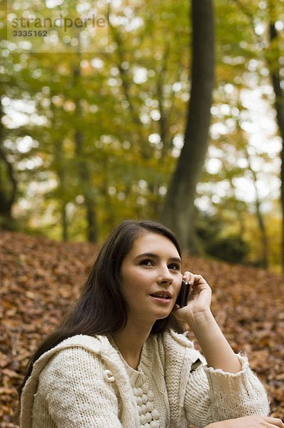 Mädchen am Telefon im Wald