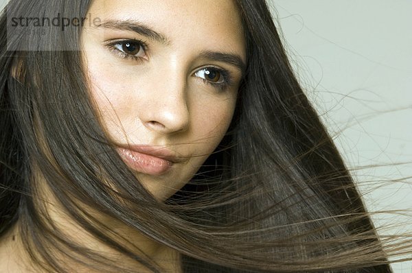 Haare blasen über das Gesicht von Mädchen