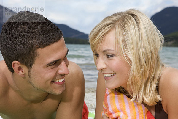Ein junges Paar lächelt sich an.