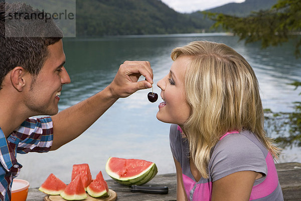 Ein junges Paar beim Picknick am See