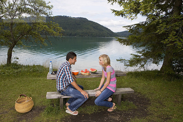Ein junges Paar beim Picknick am See