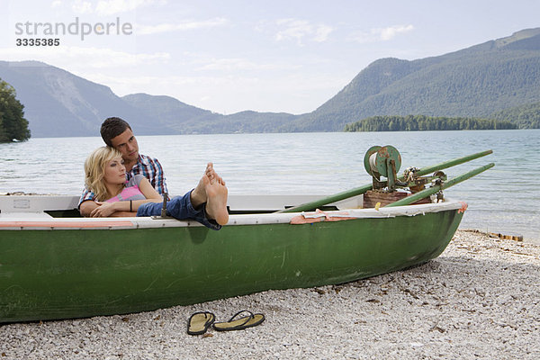 Ein junges Paar träumt in einem Boot.