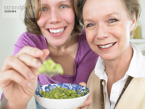 Großmutter und Mutter füttern Baby