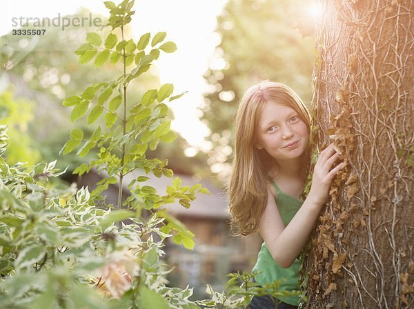 Junges Mädchen  das von hinten auf den Baum blickt