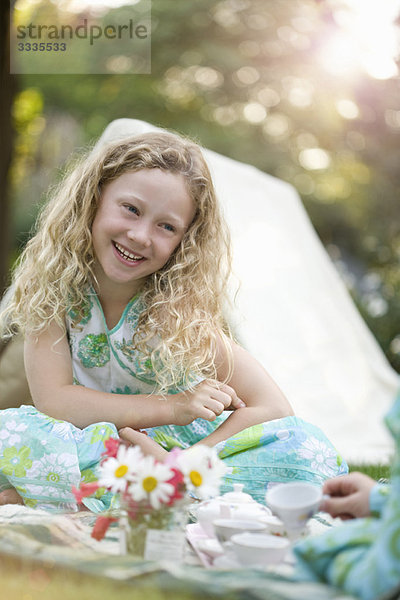 junges Mädchen lächelnd beim Spiel Picknick