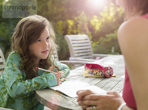 Junges Mädchen und Mutter beim Plaudern im Garten