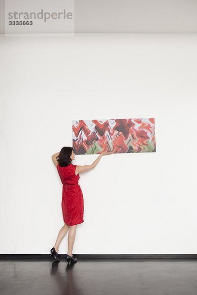 woman hanging up a picture