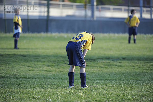 Young boy with head down  in soccer match