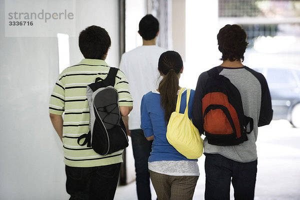 Schüler gehen gemeinsam im Flur  Rückansicht