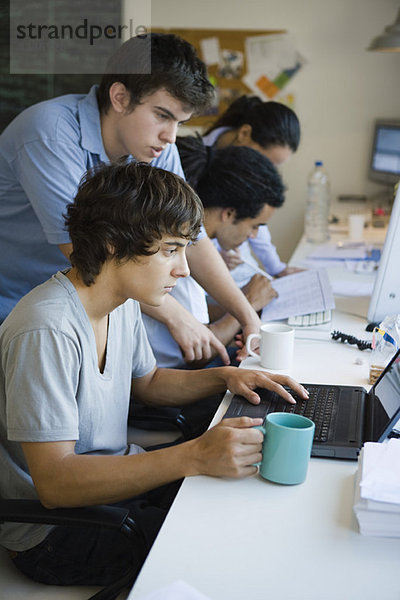 Männliche Studenten arbeiten zusammen mit Laptop-Computer