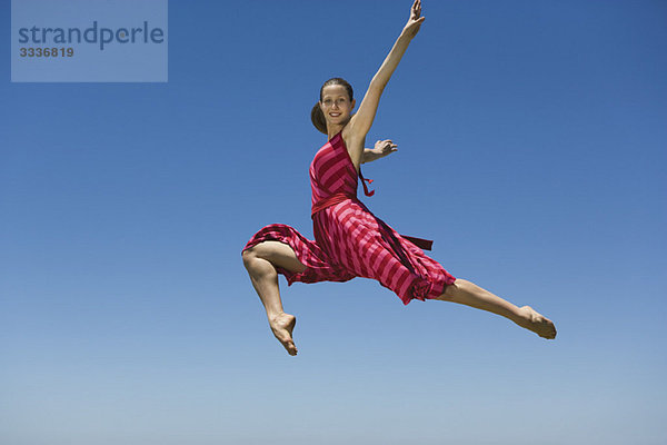 Junge Frau springt  mitten in der Luft