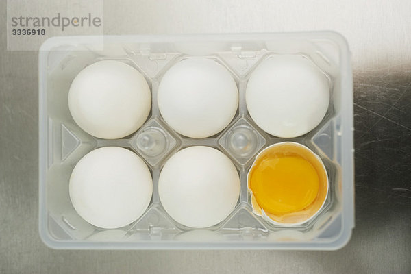 Eier im Eierkarton  eines aufgesprungen
