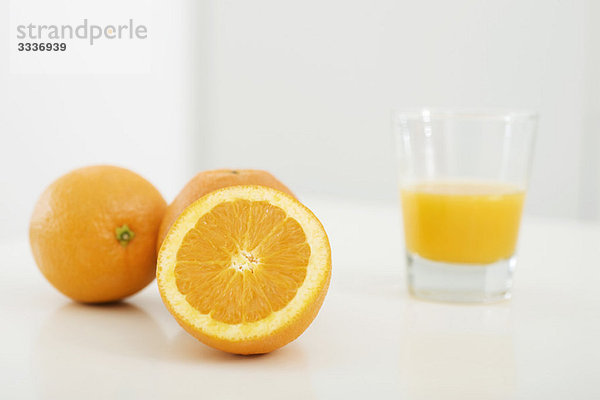 Orangen und ein Glas Orangensaft
