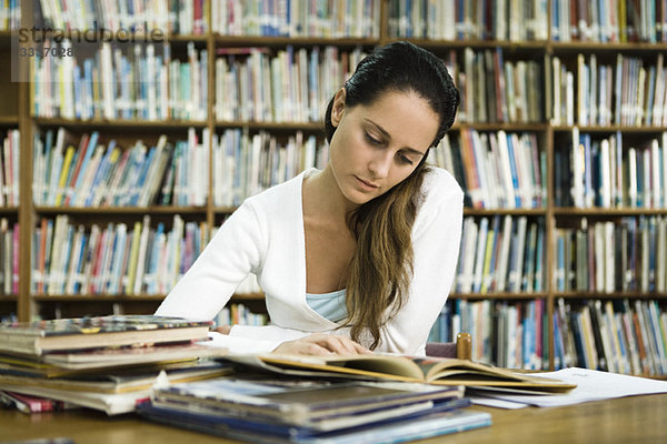 Frau liest in der Bibliothek