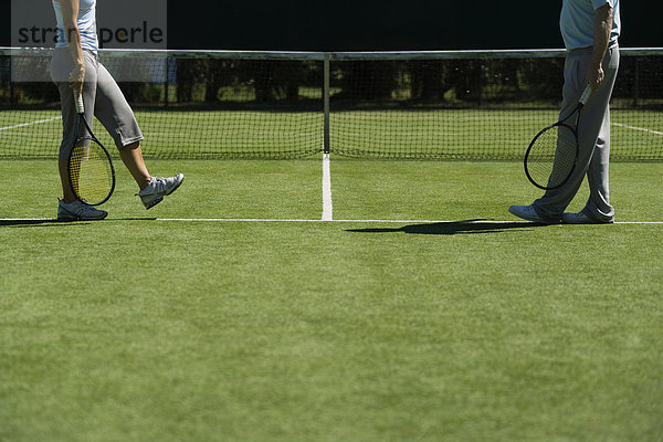 Tennisspieler  die über den Platz gehen  um sich zu treffen.