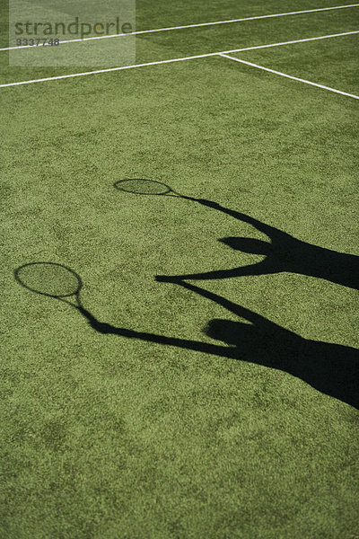 Schatten von Tennisspielern  die zur Feier des Tages ihre Hände heben.