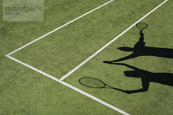 Schatten von Tennisspielern  die zur Feier des Tages ihre Hände heben.