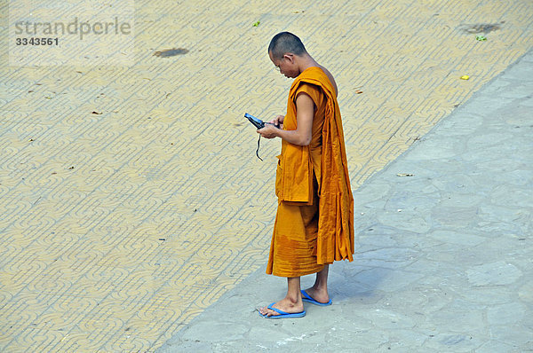 Buddhistischer Mönch schaut auf Handys  Angkor  Kambodscha  Erhöhte Ansicht