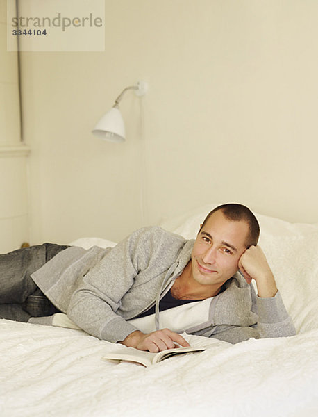 Portrait of a mid-adult Man in einem Bett  Schweden.