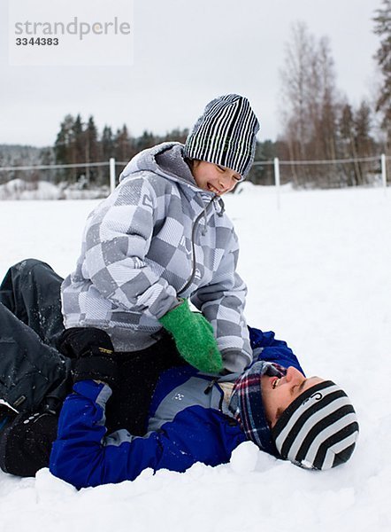 Vater und Sohn spielen im Schnee  Schweden.