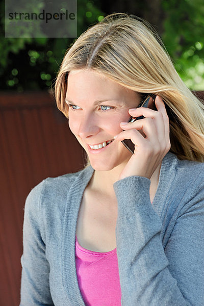 Einer blonden Frau mit ihrem Mobiltelefon  Schweden.