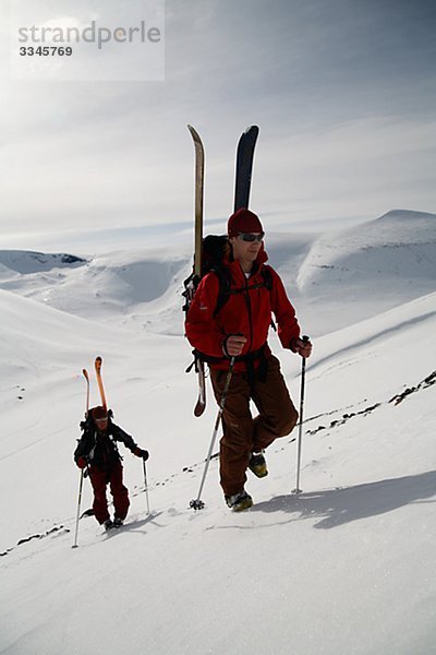 Zwei Skifahrer Wandern bergauf  Abisko  Lappland  Schweden.