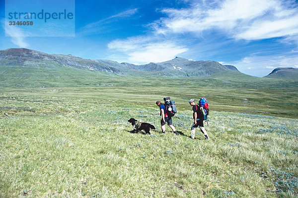 Zwei Personen mit einem Hund auf eine Bergtour  Schweden.