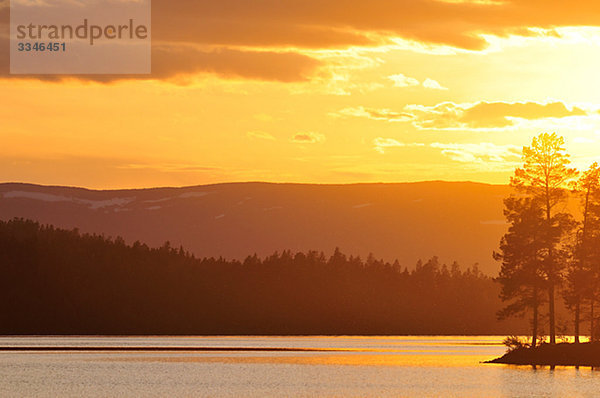 Ein See bei der Einstellung der Sonne  Schweden.
