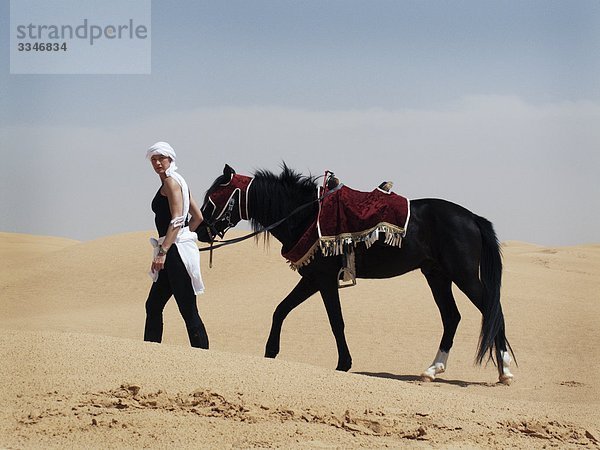 Frau mit einem Pferd in der Wüste  Tunesien.