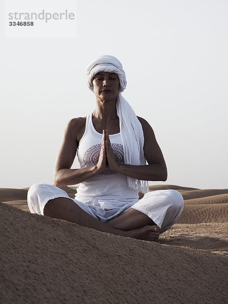 Frau durchführen Yoga in der Wüste  Tunesien.