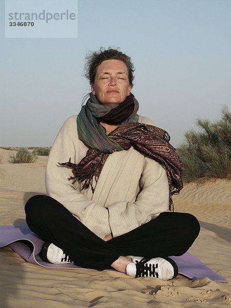 Frau meditierend in der Wüste  Tunesien.