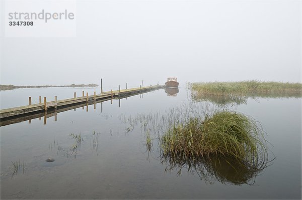 Lake hüllte in Nebel in der Dämmerung  Schweden.