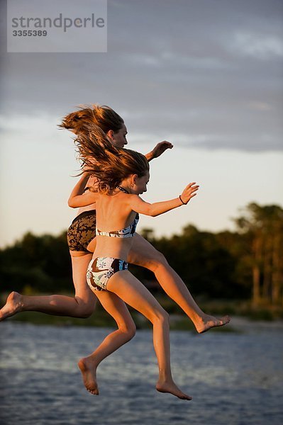 Eine Frau und ein Mädchen springen ins Wasser  Schweden.