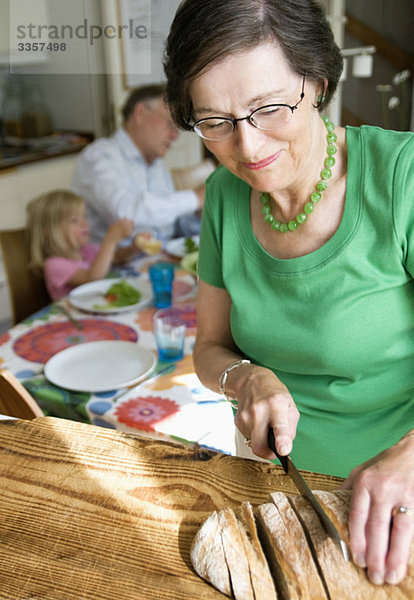 Großmutter beim Brotschneiden