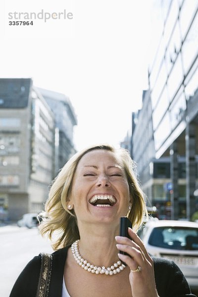 Lachende Geschäftsfrau im Gespräch mit dem Handy