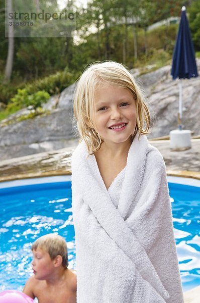 Mädchen steht neben dem Freibad