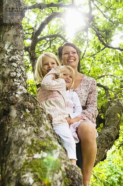 Mutter und zwei Töchter sitzender Baum