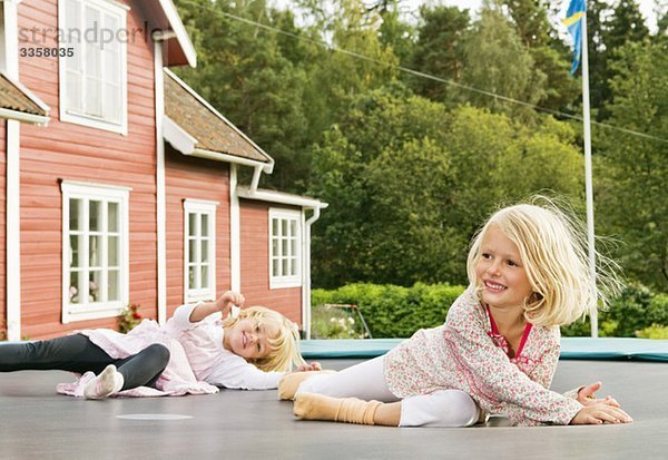 Zwei Schwestern auf Rebouncer liegend