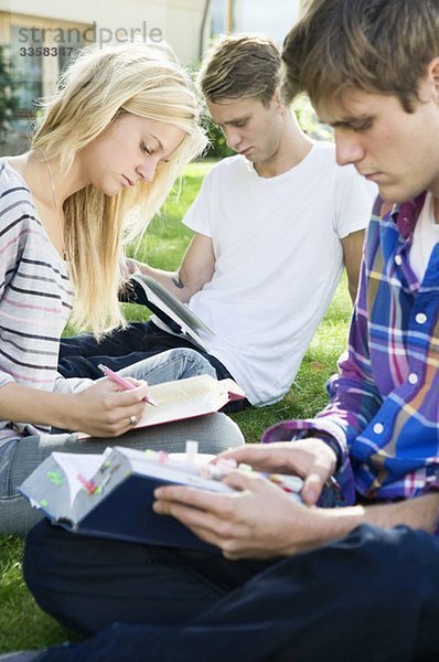 Schüler sitzen außerhalb des Studiums
