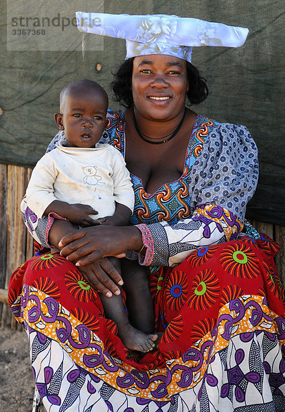 Volk der Herero  Local  einheimischen  Eingeborenen  Native  Kunene Region  Namibia  Afrika  Frau  Mutter  Kind  lächelnd  bunten  bunte  Porträt  Hut