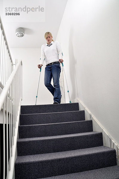 Frau  Frau  Fußböden  Sticks  Krücken  gefährlich  nur  hilflos  behindert  Treppenhaus  Hall  Treppe  Hindernis zu Fuß-behindert  geeignet für Behinderte