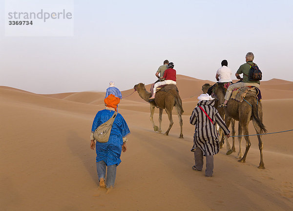 Touristen auf einem Kamel reiten  Merzouga-Dünen  Sahara  Marokko