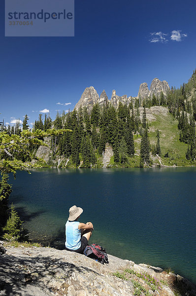Frau sitzt auf Stein über Blue Lake  North Cascades National Parks  Washington  USA